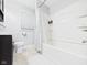 Bright bathroom featuring a white shower-tub, modern vanity, toilet, neutral tile flooring and a window with blinds at 624 10Th St, Chesterfield, IN 46017