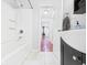 Bright bathroom featuring a shower-tub combo, modern vanity, and a glimpse into the home's interior with hardwood flooring at 624 10Th St, Chesterfield, IN 46017