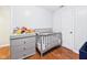 Bedroom with hardwood floors, crib, toys, and a chest of drawers at 624 10Th St, Chesterfield, IN 46017