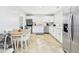 Well-lit kitchen featuring white cabinetry, stainless steel appliances, and a dining area at 624 10Th St, Chesterfield, IN 46017