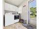 Functional laundry area with washer, dryer, storage cabinets, neutral tile flooring and exterior door at 624 10Th St, Chesterfield, IN 46017