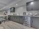 Basement bar featuring gray cabinets, countertops, beverage refrigerator, and wood-look floors at 6525 Carolina Blvd, Indianapolis, IN 46217
