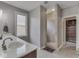 Bright bathroom with a single sink, a large mirror, a shower, a window and a walk-in closet at 6525 Carolina Blvd, Indianapolis, IN 46217