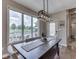 Bright dining room featuring a large window with a pool view, stylish lighting, and hardwood flooring at 6525 Carolina Blvd, Indianapolis, IN 46217