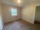 Neutral bedroom with carpet flooring, a window for natural light, and closet access at 667 E Edgewood Ave, Indianapolis, IN 46227