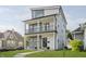 Stunning three-story home featuring modern architectural details, two balconies, and manicured lawn at 704 Parkway Ave, Indianapolis, IN 46203