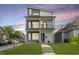 Modern two-story home with a well-manicured lawn, gray and white siding, and a second-story balcony at 704 Parkway Ave, Indianapolis, IN 46203