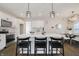 Modern kitchen featuring white cabinets, a central island with seating, and elegant pendant lighting at 704 Parkway Ave, Indianapolis, IN 46203