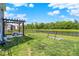 Expansive backyard featuring a pergola, well-maintained lawn, black fence, and a serene lake view at 741 Scarsdale Ln, Danville, IN 46122
