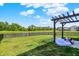Spacious backyard with a pergola, lake view, and black metal fence, perfect for outdoor enjoyment at 741 Scarsdale Ln, Danville, IN 46122