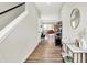 Bright hallway with wood flooring, showcasing a stylish console table, decorative mirror, and an open view into the living area at 741 Scarsdale Ln, Danville, IN 46122
