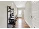 Inviting hallway with wood floors, featuring a modern shelving unit and a view of the front door and staircase at 741 Scarsdale Ln, Danville, IN 46122