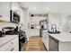 Galley kitchen with granite countertops, stainless appliances, ample cabinets, and hardwood floors at 741 Scarsdale Ln, Danville, IN 46122
