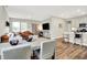 Open concept eat-in kitchen and living room with large sectional sofa, hardwood floors, and natural light at 741 Scarsdale Ln, Danville, IN 46122