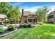 Backyard of a brick house featuring a covered patio, a fire pit, and green grass at 7648 W Williamswood Dr, New Palestine, IN 46163