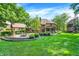 Wide view of the brick home's backyard with a covered patio and fire pit at 7648 W Williamswood Dr, New Palestine, IN 46163