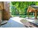 Backyard featuring a covered patio, fire pit, and well-manicured landscaping at 7648 W Williamswood Dr, New Palestine, IN 46163