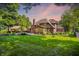 Spacious backyard with well-manicured lawn, inviting gazebo, and mature trees under a beautiful dusk sky at 7648 W Williamswood Dr, New Palestine, IN 46163
