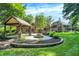 Beautiful backyard featuring a fire pit, a covered patio, and green grass at 7648 W Williamswood Dr, New Palestine, IN 46163