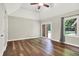 Bright bedroom with hardwood floors, ceiling fan, tray ceiling, and sliding doors to a private outdoor area at 7648 W Williamswood Dr, New Palestine, IN 46163