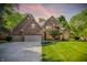 Charming brick home boasts a manicured lawn, mature trees, and a three-car garage, perfect for Gathering living at 7648 W Williamswood Dr, New Palestine, IN 46163