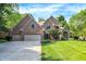 Charming brick home boasts a manicured lawn, mature trees, and a three-car garage, perfect for Gathering living at 7648 W Williamswood Dr, New Palestine, IN 46163