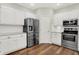 Modern kitchen with stainless steel appliances, white cabinets, tile backsplash, and granite countertops at 7648 W Williamswood Dr, New Palestine, IN 46163