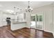 Eat-in kitchen featuring white cabinets, stainless appliances, bar seating, and sliding door access to the sunroom at 7648 W Williamswood Dr, New Palestine, IN 46163