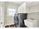Well-equipped laundry room featuring modern washer and dryer, ample storage cabinets, and a convenient utility sink at 7648 W Williamswood Dr, New Palestine, IN 46163