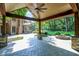 View of the backyard from the covered patio, featuring a fire pit and lush greenery at 7648 W Williamswood Dr, New Palestine, IN 46163