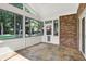 Inviting sun room with brick accent wall and many windows, offering serene views of the lush greenery outdoors at 7648 W Williamswood Dr, New Palestine, IN 46163