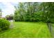 Well-manicured backyard with lush green lawn, mature trees, and secure fence at 7833 Meadow Bend Dr, Indianapolis, IN 46259