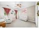 Charming Bedroom featuring a crib, accent wall, and cozy seating area, designed to create a warm and inviting space for a baby at 7833 Meadow Bend Dr, Indianapolis, IN 46259