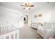 Bright Bedroom featuring a crib, glider, and changing table, designed to create a warm and inviting space for a baby at 7833 Meadow Bend Dr, Indianapolis, IN 46259