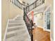 A welcoming foyer features a staircase with black railings and hardwood floors at 7833 Meadow Bend Dr, Indianapolis, IN 46259