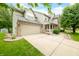 Two story home featuring a two car garage, green lawn, mature landscaping, and inviting porch at 7833 Meadow Bend Dr, Indianapolis, IN 46259