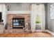 Cozy brick fireplace with decorative mantle, adjacent to a window with natural light at 7833 Meadow Bend Dr, Indianapolis, IN 46259