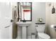 Half-bath offers patterned wallpaper, pedestal sink, and wood-look floors at 7833 Meadow Bend Dr, Indianapolis, IN 46259