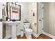 Stylish half bathroom features a pedestal sink and decorative wallpaper at 7833 Meadow Bend Dr, Indianapolis, IN 46259