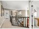 Hallway with dark railing, neutral walls, and decorated with framed pictures at 7833 Meadow Bend Dr, Indianapolis, IN 46259