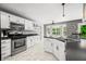 Spacious kitchen with stainless steel appliances, white cabinetry, and dark countertops at 7833 Meadow Bend Dr, Indianapolis, IN 46259