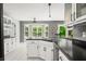 Bright kitchen featuring white cabinets, black countertops, breakfast bar, and an adjacent breakfast nook at 7833 Meadow Bend Dr, Indianapolis, IN 46259