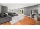 Open living room with hardwood floors, gray sofa, and access to backyard at 7833 Meadow Bend Dr, Indianapolis, IN 46259