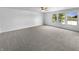 Spacious bedroom with plush carpet, ceiling fan, and sunlit windows with a water view at 7854 Wolfgang Pl, Indianapolis, IN 46239
