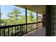 View from covered deck with wooden railing overlooking mature trees and foliage at 8176 Shorewalk Dr # C, Indianapolis, IN 46236