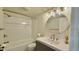 Bright bathroom features a modern vanity, round mirror and a tiled shower over tub at 8176 Shorewalk Dr # C, Indianapolis, IN 46236