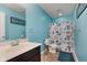 Bright bathroom featuring a vanity, toilet, and shower with a decorative blue-themed shower curtain at 985 Farmington Trl, Brownsburg, IN 46112