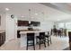 Stylish kitchen with dark cabinets, island with seating, and adjacent dining area for a perfect blend of cooking and socializing at 985 Farmington Trl, Brownsburg, IN 46112