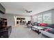 Open-concept living room area with carpet and large windows with living room and partial view of the kitchen at 985 Farmington Trl, Brownsburg, IN 46112