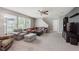 Comfortable living room with carpet, large windows, ceiling fan, and gray couches with orange pillows at 985 Farmington Trl, Brownsburg, IN 46112